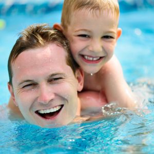 man and boy swimming in pool